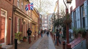 exterior view of historic Elfreth's Alley with people walking past buildings in Philadelphia, Pennsylvania, USA